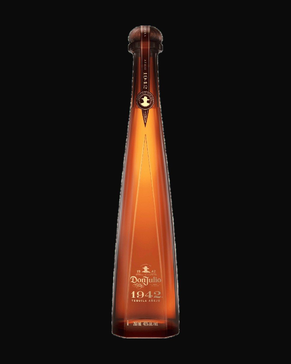 Bottle of Don Julio 1942 Añejo, tequila, from Jalisco, Mexico, 750ml — a clear agave spirit bottle on charred stone with lime and salt