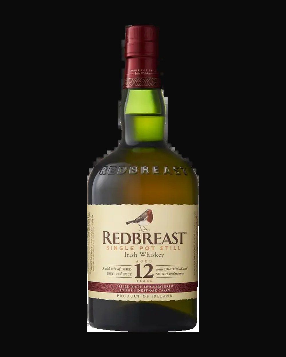 Bottle of Redbreast 12 Year Single Pot Still, irish whiskey, from Cork, Ireland, 750ml — an amber whiskey bottle lit against dark oak and cut crystal